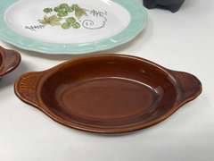 Assorted kitchen items to include a vintage Corona ironstone ware platter, restaurant style salsa bowl, vintage Bel-Terr brown glazed au gratin baking dishes, and plastic Christmas plate. Five pieces total, see pictures for detail details.