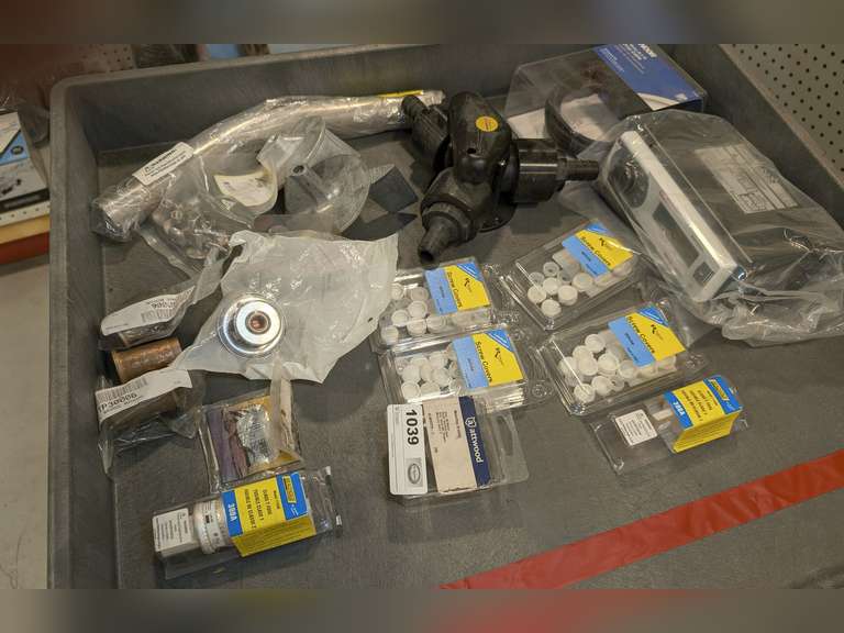ASSORTED MARINE PARTS INCLUDING BAITWELL PLUGS, ZINC TRIM TAB ANODES, MARINE RADIO, BRASS FITTINGS, AND MORE image