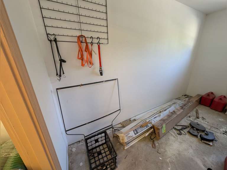 CONTENTS OF LEFT SIDE OF STORAGE ROOM INCLUDING WALL MOUNT STORAGE RACK, CARGO STRAPS, FLUORESCENT LIGHT BULBS AND ASSORTED ITEMS image