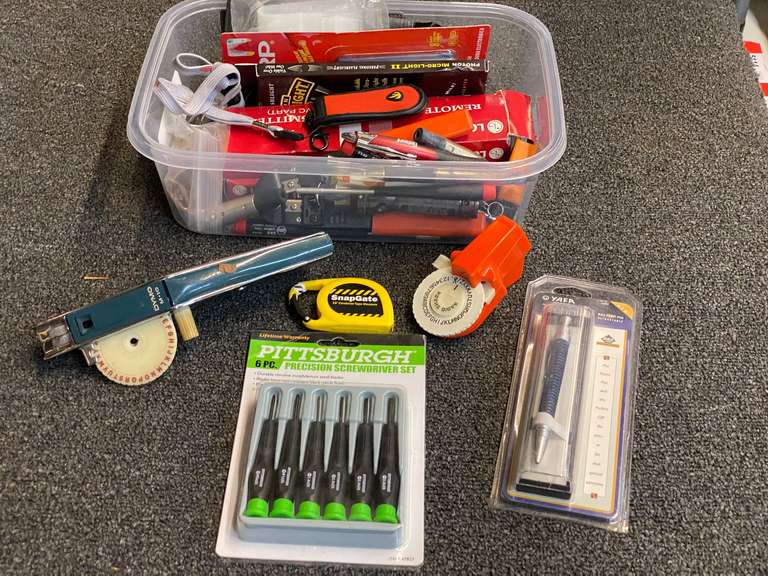 Assortment of small hand tools, pens, remote controls, and more. Tub is not included. See pictures for details. image