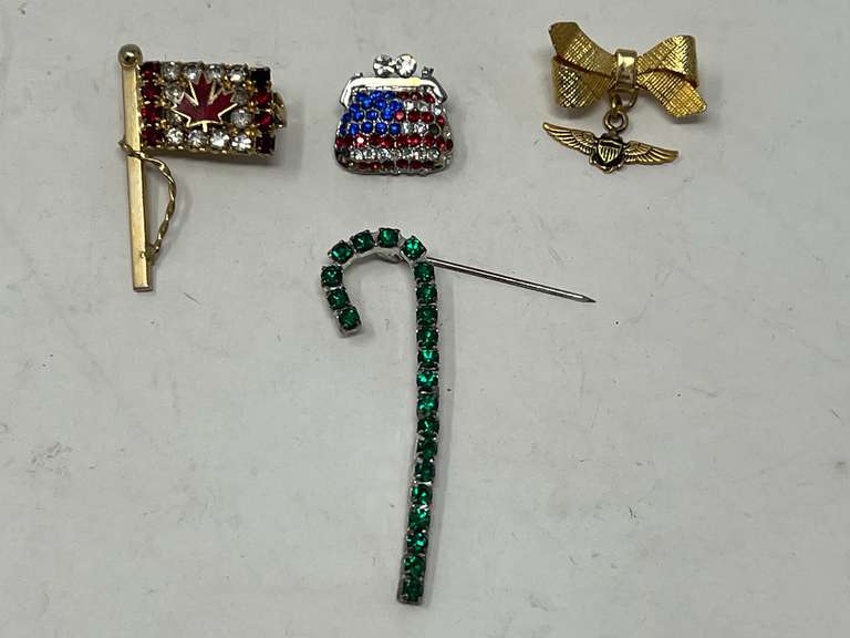 Ladies fashion brooches to include a Canadian rhinestone brooch, a gold tone petite brooch with wings charm, and more . Four pieces, see pictures for details. image