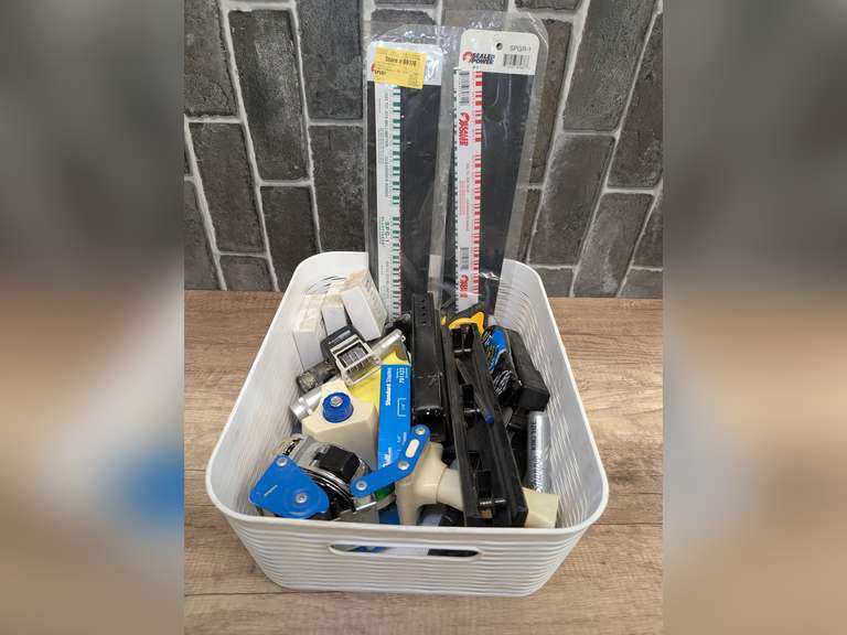 WHITE BASKET FILLED WITH TOOLS, OFFICE SUPPLIES, AND MORE INCLUDING PLASTIGAGE, UTILITY KNIFE BLADES, TAPE MEASURES, STAPLERS, AND MORE image
