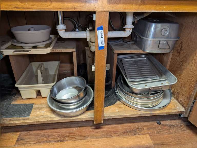 CONTENTS OF UNDER SINK CABINET INCLUDING METAL MIXING BOWLS, BAKING PANS, ALUMINUM ROASTER, AND MORE image