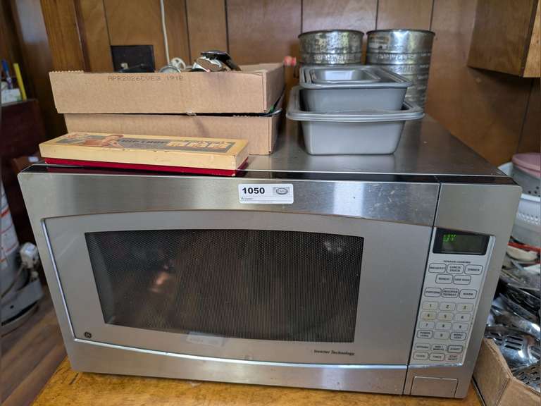 GE MICROWAVE AND ITEMS ON TOP INCLUDING KITCHEN UTENSILS, MEAT THERMOMETERS, VINTAGE BROMWELL SIFTERS, AMAZING CHIP CHOP IN ORIGINAL BOX, AND MORE image