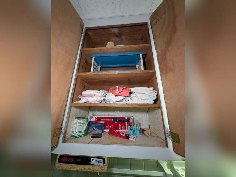 CONTENTS OF CABINET MARKED 1324 INCLUDING THERMOMETERS, BANDAGES, BATHROOM WALL ART, AND OPTIMIST UNDER CABINET RADIO image