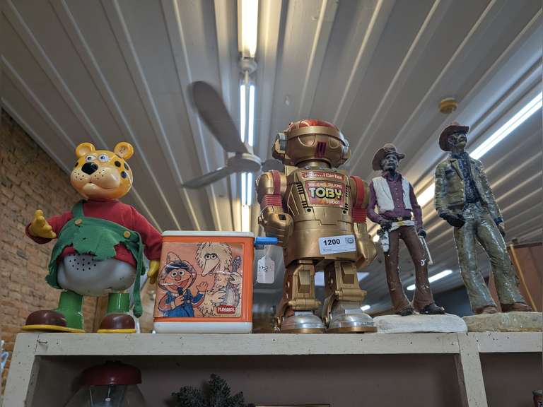 VINTAGE TOYS AND CHALKWARE COWBOY FIGURINES ON TOP OF BOOKCASE MARKED 1200 image