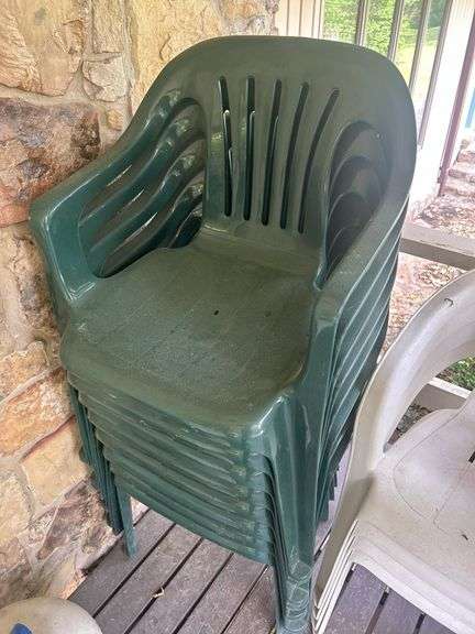 Stack of Green Plastic Outdoor Chairs image
