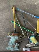Assorted Cleaning Supplies: Mops, Brooms, and Caution Sign