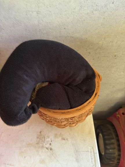 Wicker Basket with Assorted Scarves, Black Neck Pillow and Other Textile Items image