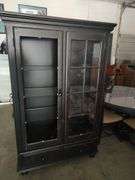 AMERICAN SIGNATURE - LIGHTED 2 DOOR CURIO CABINET - DISTRESSED LOOK - MISSING GLASS FOR LEFT SIDE DOOR - HAS 3 GLASS SHELVES AND 2 BOTTOM DRAWERS - 47X18X73