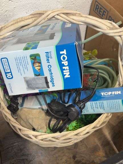 WHITE BASKET WITH VARIOUS AQUARIUM PIECES IN IT image