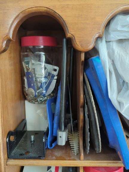 Wall-Mounted Wooden Shelf with Assorted Hardware and Tools
