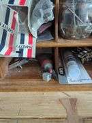 Wall-Mounted Wooden Shelf with Assorted Hardware and Tools