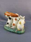 Whimsical Ceramic Figurine of Three Rabbits Carrying a Carrot