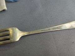 Assorted Silver Plated Items: Flatware, Coasters, and Candlestick Holders