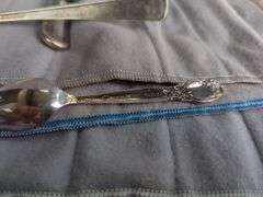 Assorted Silver Plated Items: Flatware, Coasters, and Candlestick Holders