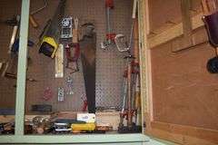Numerous hand tools, fiels, hand saws, screw drivers, staples, hammers, clamps, chizzels, safety glasses, brushes, picks, rulers, etc.