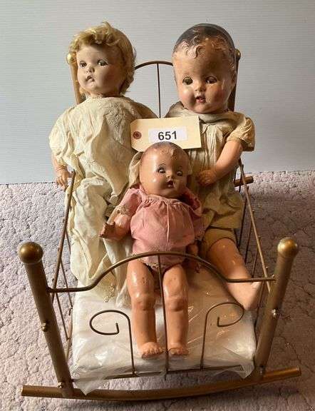 Three Antique Dolls In A Cradle image