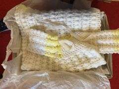 Box of crochet baby items and box of children’s shoes