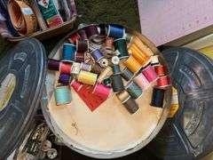 Longaberger divided basket with sewing items and plastic sewing basket with cutting mat and spools of thread