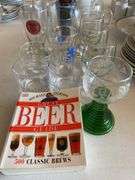 Clear glass pitcher, bar glasses, beer guide book