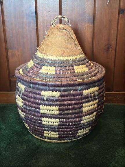 Hand woven basket with a conical leather lid 22” tall
