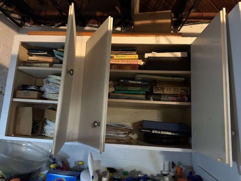 Inside of top of cabinet in basement. Lots of books & some dishes