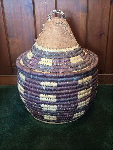 Hand woven basket with a conical leather lid 22” tall
