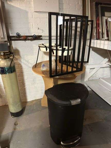 Step trash can, gate, round table, pair of tall dog dishes. In basement image