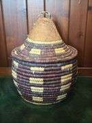 Hand woven basket with a conical leather lid 22” tall