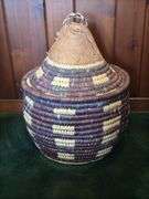 Hand woven basket with a conical leather lid 22” tall