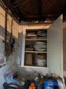 Inside of top of cabinet in basement. Lots of books & some dishes