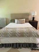 Queen size bed with bedding. Upholstered headboard