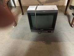 Old Sony tv, floor lamp, Yamaha stereo cassette deck, DVDs,  Panasonic movie camera, & canon movie camera. In basement