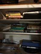Inside of top of cabinet in basement. Lots of books & some dishes