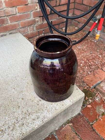Outside decor, crock with chips on lip, insulator, concrete pedestal, 4 plastic pots with flowers image