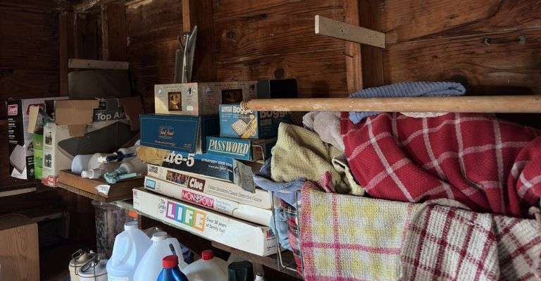 Contents of top shelf: games, spray bottles, rags image