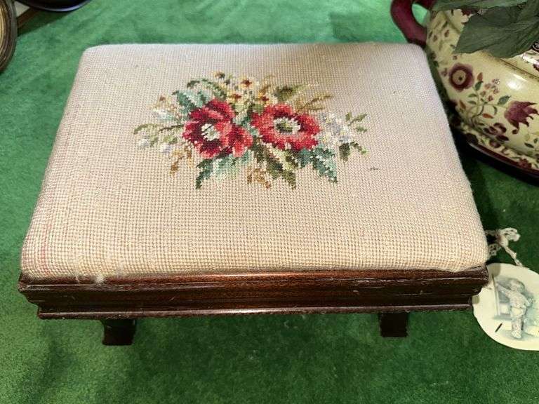 Needlepoint step stool, large floral arrangement in ceramic planter, sand dollar ornament