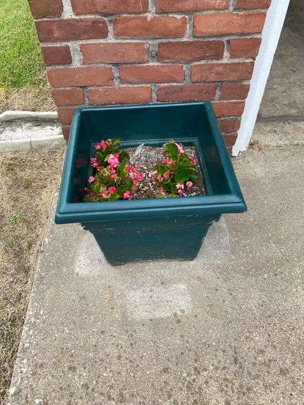 Outside decor, crock with chips on lip, insulator, concrete pedestal, 4 plastic pots with flowers