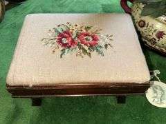 Needlepoint step stool, large floral arrangement in ceramic planter, sand dollar ornament