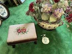 Needlepoint step stool, large floral arrangement in ceramic planter, sand dollar ornament