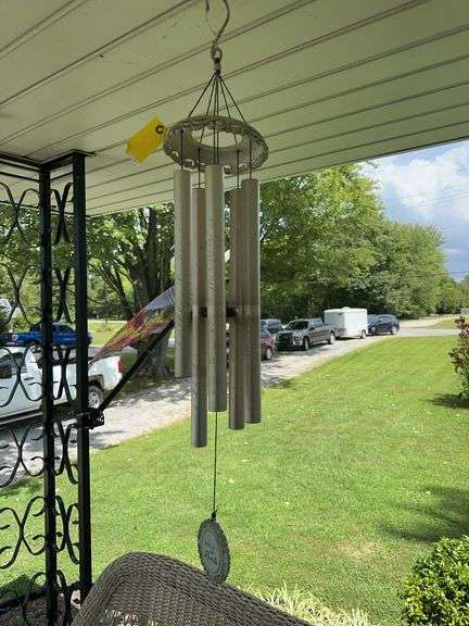 3 windchimes, flag, man on stump image
