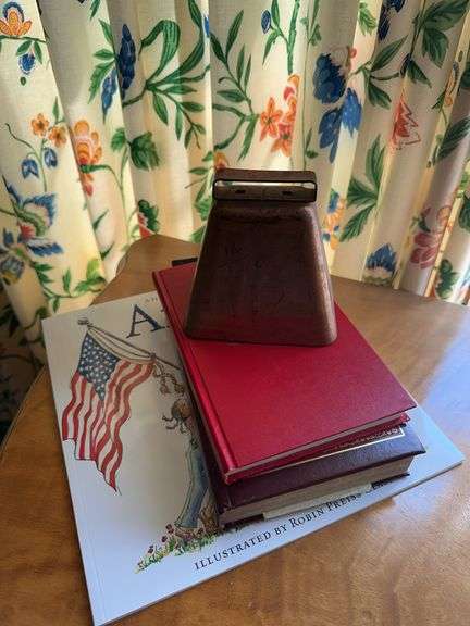Copper cow bell, bible, coin book, America paper back book image