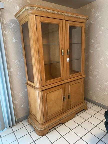 Large lighted cabinet with glass doors and shelves image