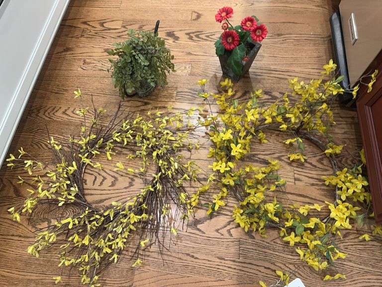 Yellow floral wreath, red floral in vase, metal watering can with greenery image