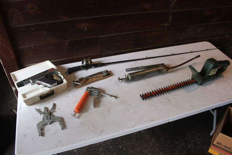 Grease Gun, 18 in Black and Decker Hedge Trimmer, Zebco 33 Reel and Lews Rod, Penske Timing Light, Pistol Groove Cleaner, Water Meter Wrench, Standing Light, and Ring Expander image