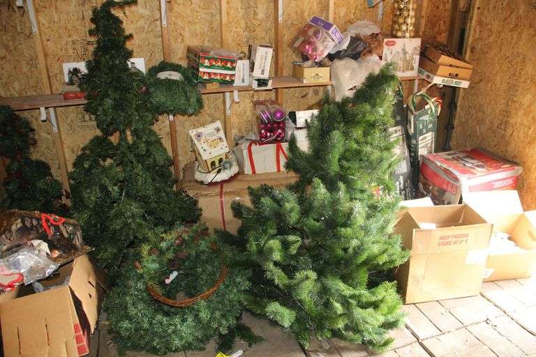 Contents of Right Side of the Shed Being Christmas Trees, Ornaments, Bells, Nativity Scene, Townhome  Figurines, Light Up Candy Canes, Santa Yard Figurine, and Misc Christmas Decorations image