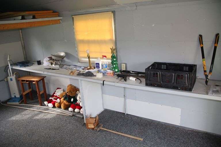 Wooden End Table, Scale Electronics Scale, Electrical Cord, Pry Bar, Level, Sensor Vacuum, Pruners, Chain Pieces, Christmas Stuffed Animals, Sledge Hammer, and Misc image