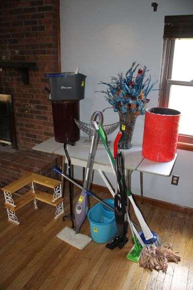 (2) Plant Stands, (2) Corner Stands, Vase and Flowers, Fruit Basket, Table with Leaf, Mops, Swiffers, (2) Mop Buckets, Cane, and Misc image
