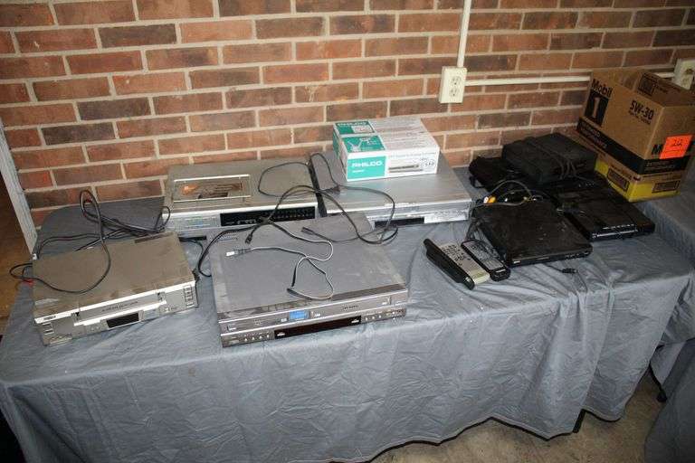 Sabre DVD Player, JVC VHS/DVD player, GPX DVD Player, Allvol DVD Player, General Instrument Alarm Clock, Samsung VHS/DVD Player, Sanyo VHS Player, Panasonic Video Cassette Recorder, and Misc Cords and Remotes image